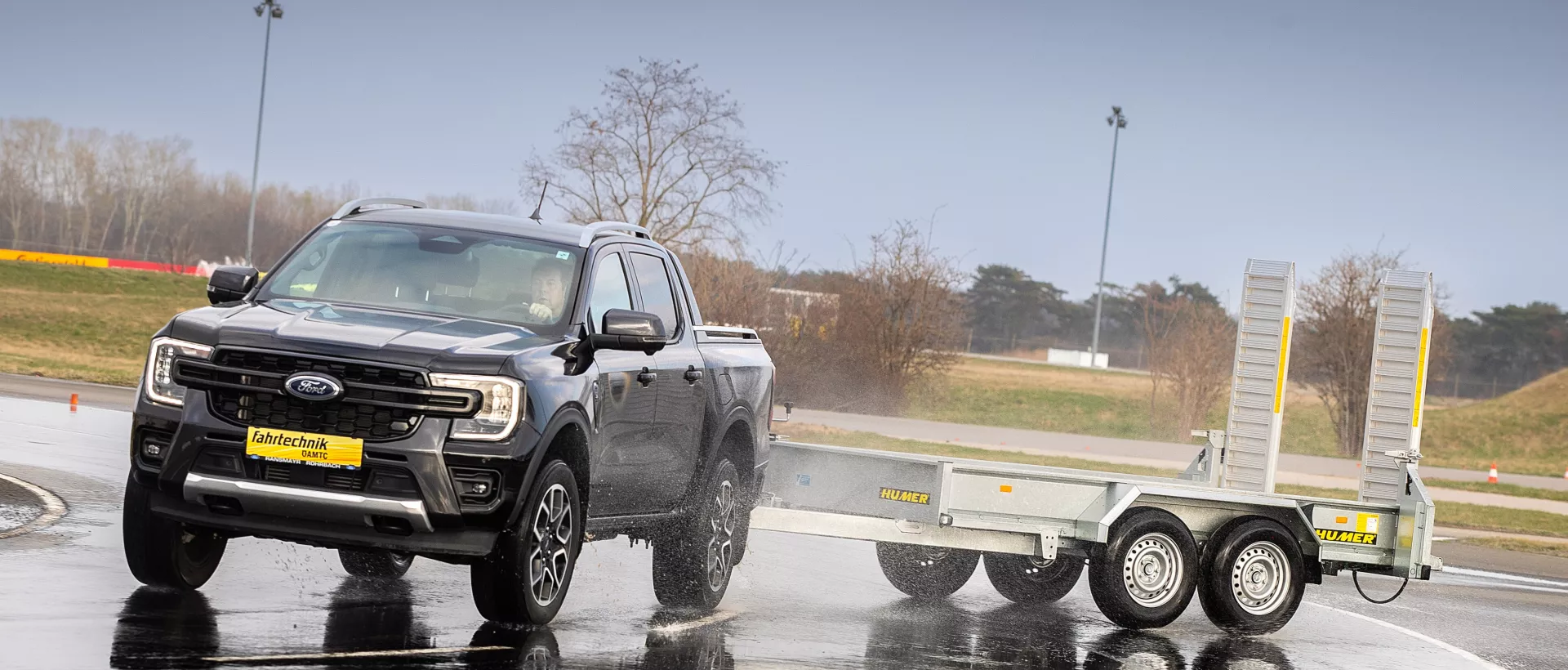 Fahrsicherheitstraining auf nasser Farhbahn mit Baumaschinenanhänger